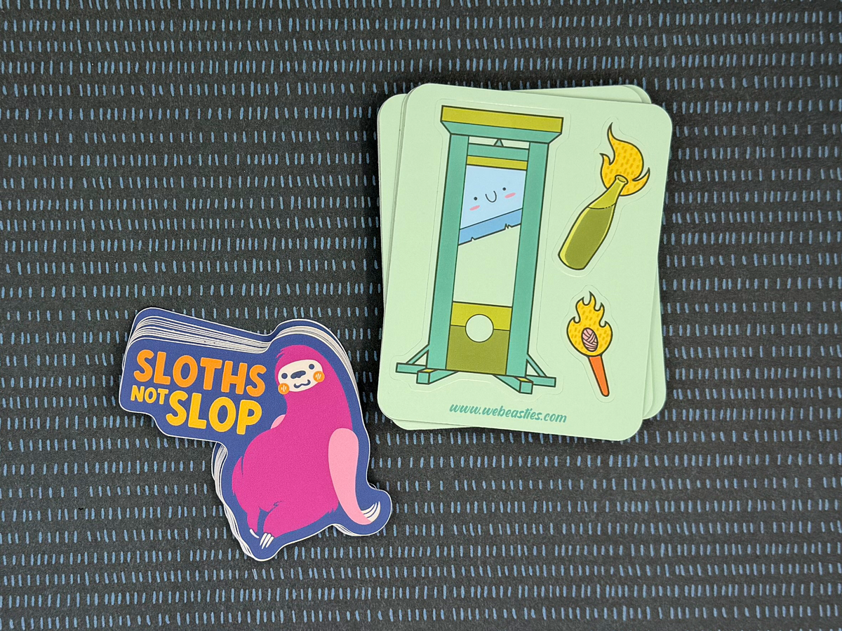 A sticker sheet with a guillotine, torch, and molotov cocktail and a sticker with an illustrated slot that says "sloths not slop"